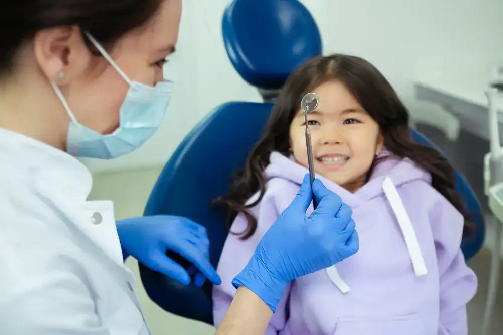 Child smiling happily in a dental chair