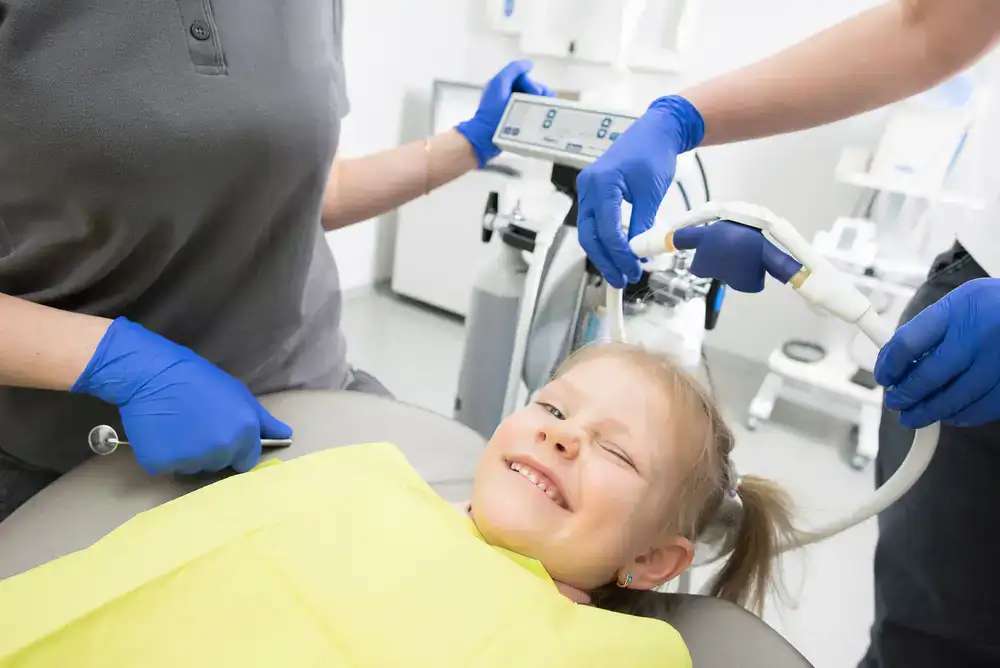 Happy child smiling in a dental chair during their first visit